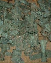 Assorted ancient bronze castings found as part of a cache, probably intended for recycling.